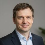 Портрет уверенного бизнесмена из компании Джуниорс Геймс на нейтральном фоне в студийном освещении