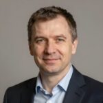 Портрет уверенного бизнесмена из компании Джуниорс Геймс на нейтральном фоне в студийном освещении