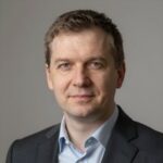 Портрет уверенного бизнесмена из компании Джуниорс Геймс на нейтральном фоне в студийном освещении